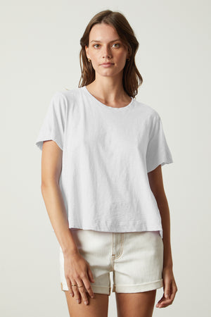 A woman wearing a white LULA COTTON SLUB SWING TEE by Velvet by Graham & Spencer and shorts.