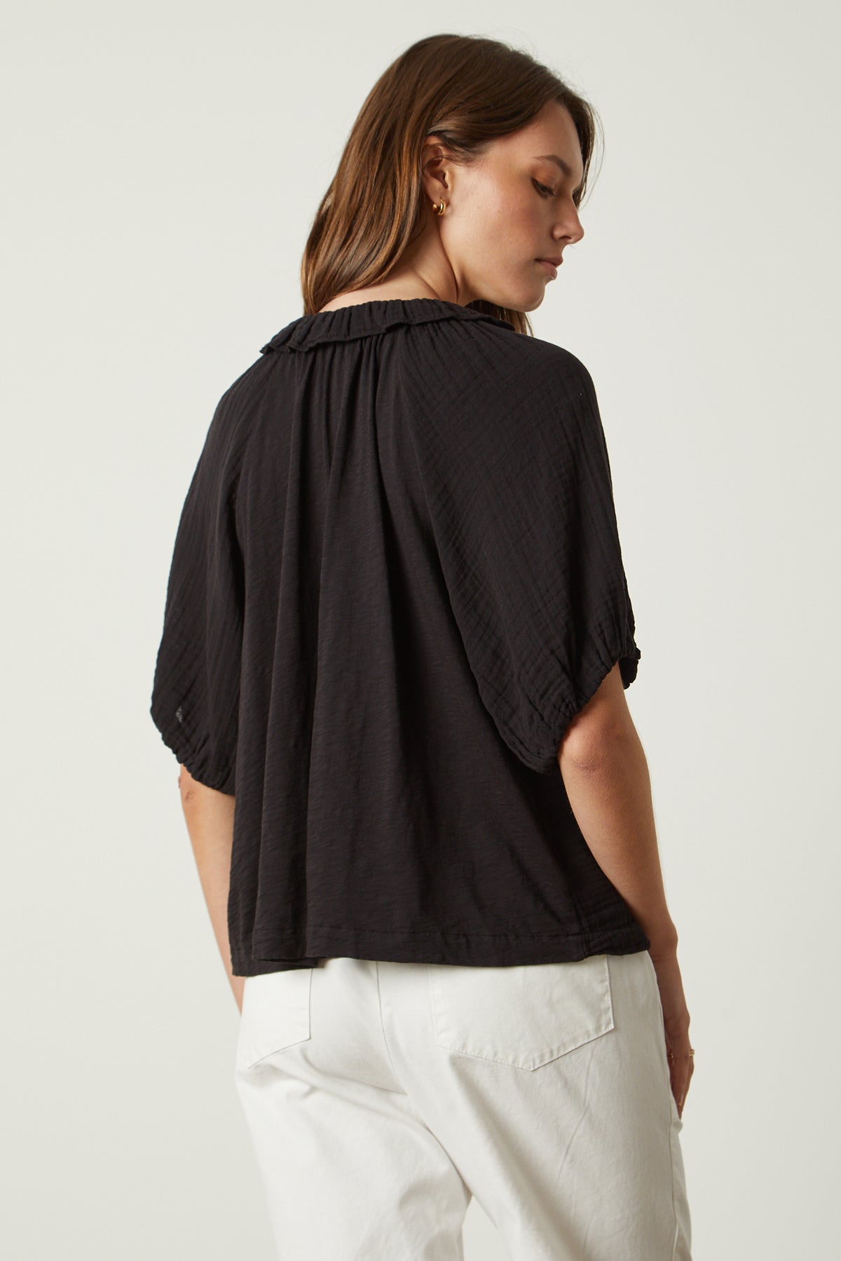   The back view of a woman wearing the Velvet by Graham & Spencer ILENE PUFF SLEEVE TOP. 