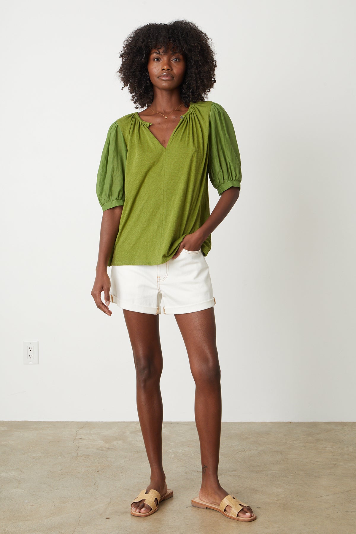 The model is wearing a MALLORY PUFF SLEEVE TOP by Velvet by Graham & Spencer and white shorts.-26255715696833