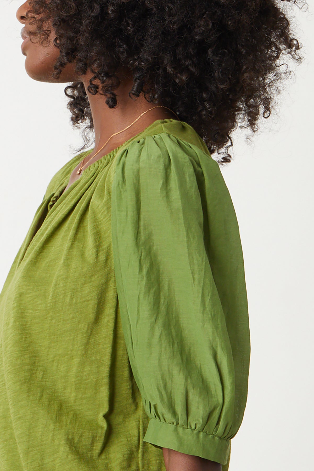   a woman wearing a Velvet by Graham & Spencer Mallory Puff Sleeve Top in green. 
