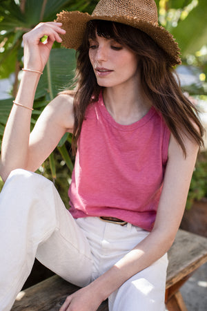 Lana Blank, a woman from New York City, stylishly dons a pink tank top and a MEDIUM MOON BRACELET BY PHYLLIS AND ROSIE straw hat.