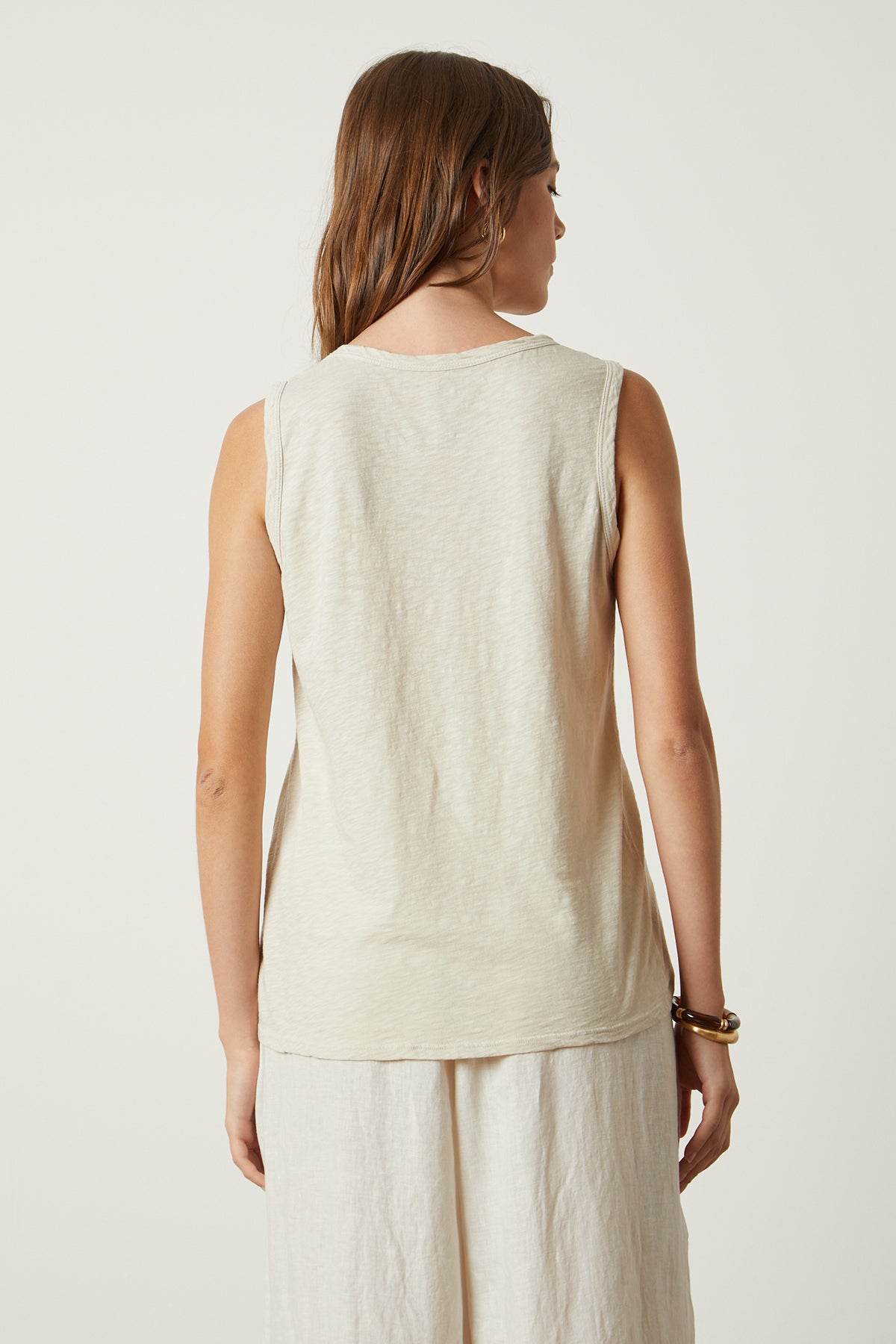 The back view of a woman wearing a Velvet by Graham & Spencer TAURUS COTTON SLUB TANK.-26022825066689