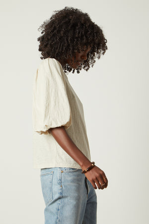 a woman wearing jeans and a Velvet by Graham & Spencer UMA PUFF SLEEVE TEE.