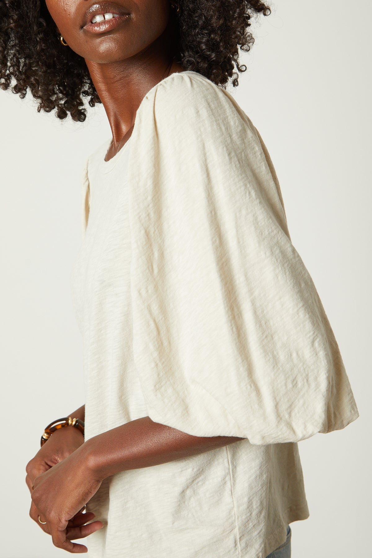   The model is wearing a white Velvet by Graham & Spencer UMA PUFF SLEEVE TEE. 