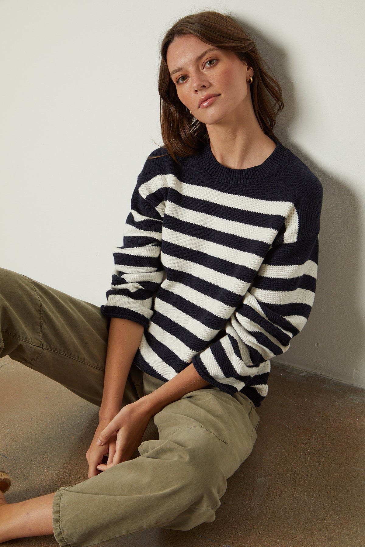   A woman wearing a Velvet by Graham & Spencer LEX STRIPED CREW NECK SWEATER and khaki pants. 