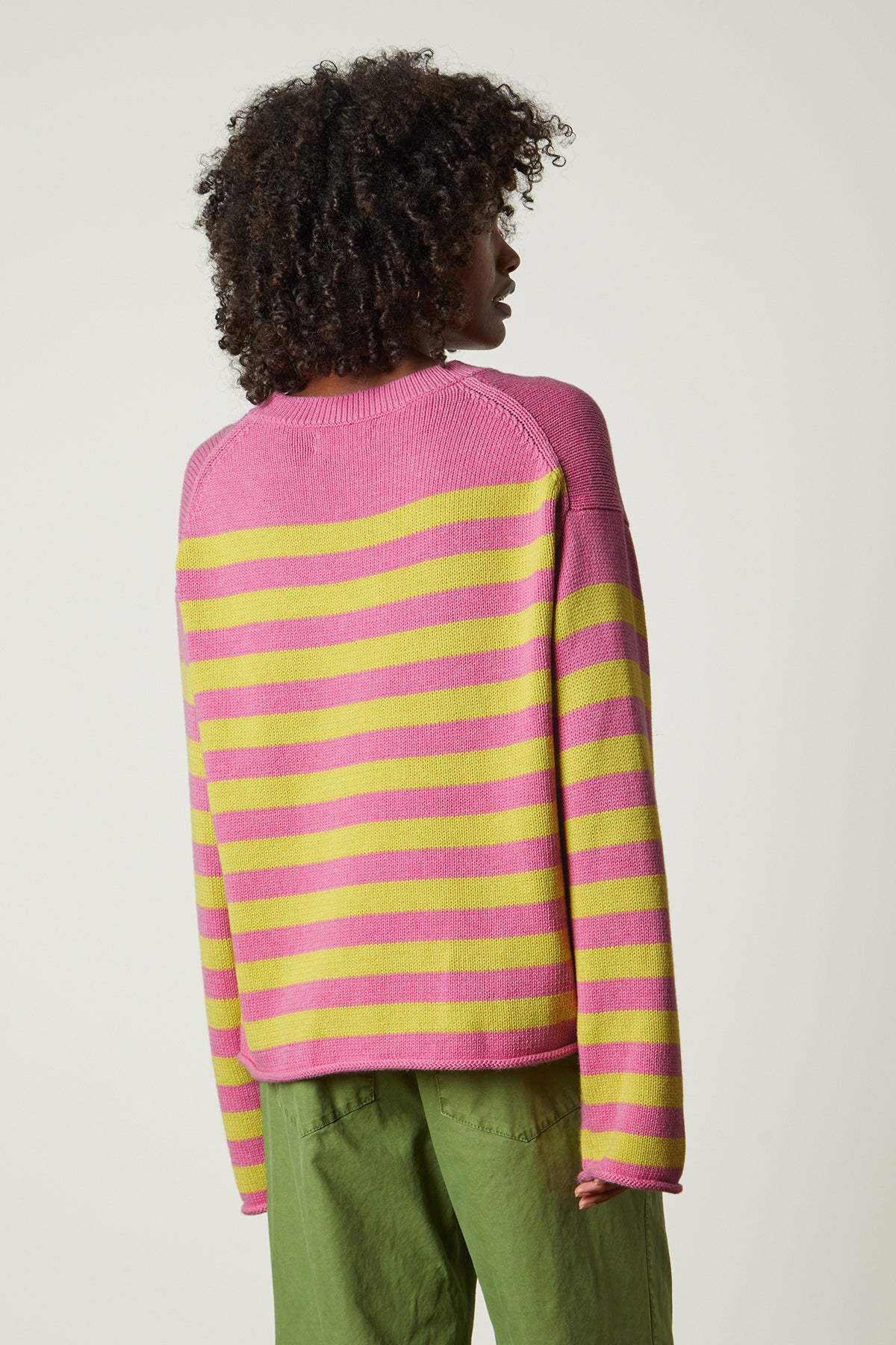 The back view of a woman wearing a Velvet by Graham & Spencer LEX STRIPED CREW NECK SWEATER.-25954607104193