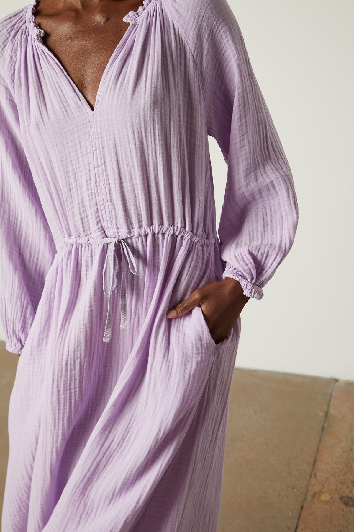   Front detail of Audrey cotton gauze dress in light lavender thistle color with model's hand in pocket 