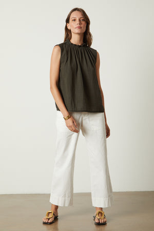 The model is wearing a Velvet by Graham & Spencer BIANCA COTTON GAUZE TANK TOP and white wide leg pants.
