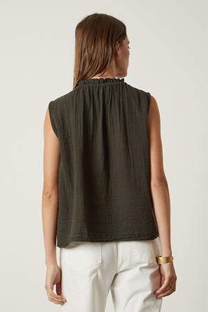 The back view of a woman wearing a Velvet by Graham & Spencer BIANCA COTTON GAUZE TANK TOP and white pants.