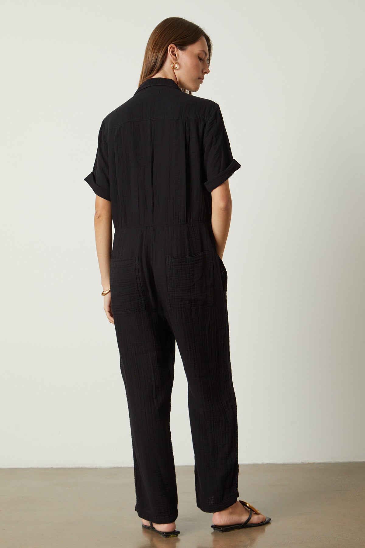   Elia jumpsuit in black with gold hoop earrings, bangle bracelet and sandals full length front back 