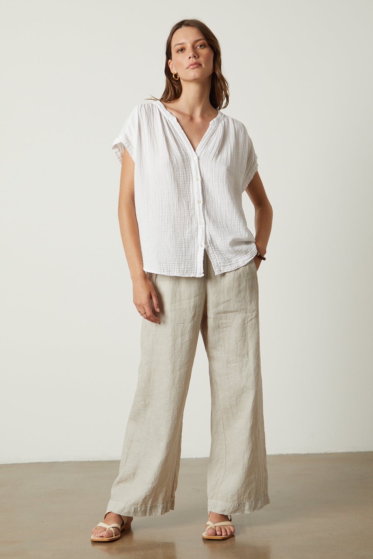 The model is wearing a Velvet by Graham & Spencer PAMELA COTTON GAUZE BUTTON-UP TOP and wide leg pants.-26022865109185