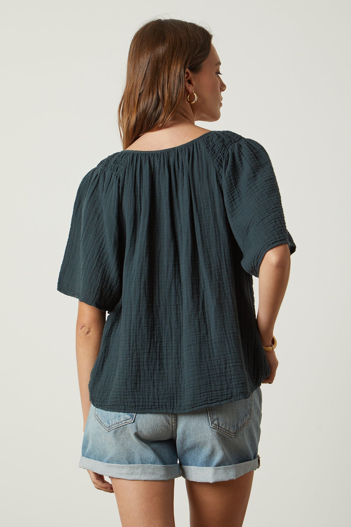   the back view of a woman wearing denim shorts and Velvet by Graham & Spencer's SADIE COTTON GAUZE V-NECK TOP. 