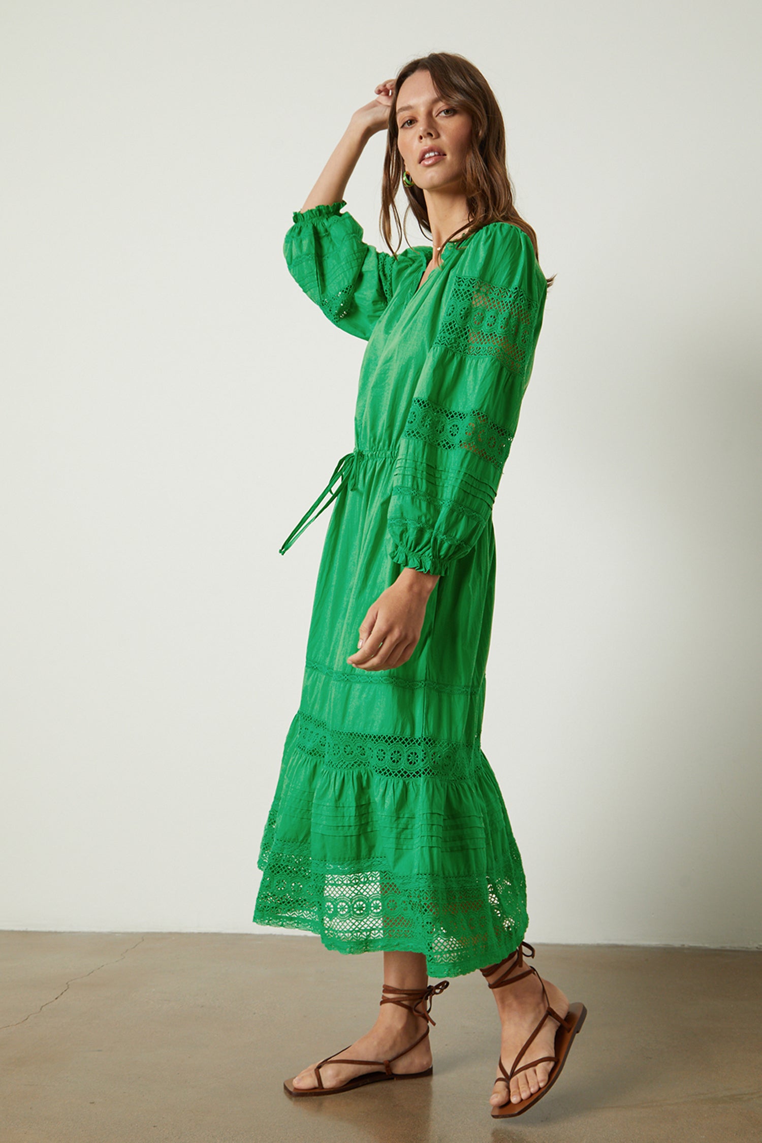   A woman wearing a green Velvet by Graham & Spencer CHANELLE COTTON LACE DRESS and sandals. 