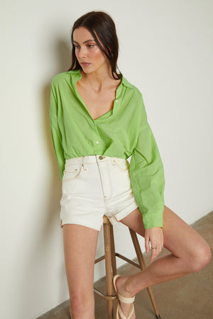 The model is wearing a Velvet by Graham & Spencer JULIA BUTTON-UP CROPPED SHIRT.