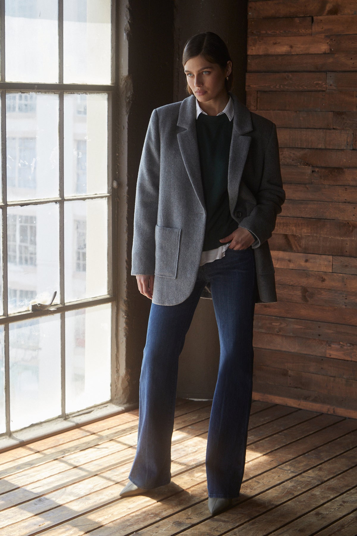 A woman in blue jeans and a Velvet by Jenny Graham ALAMOS BLAZER standing in front of a window.-25483348672705