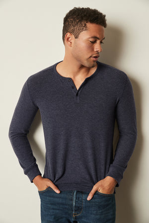 A versatile man in FAUST COZY JERSEY HENLEY by Velvet by Graham & Spencer, layering against a wall.