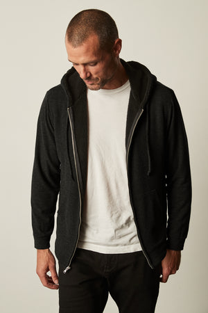 A man wearing a Velvet by Graham & Spencer SALVADORE SHERPA LINED HOODIE and white t-shirt.