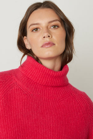 The model is wearing a Velvet by Graham & Spencer pink Judith turtleneck sweater.