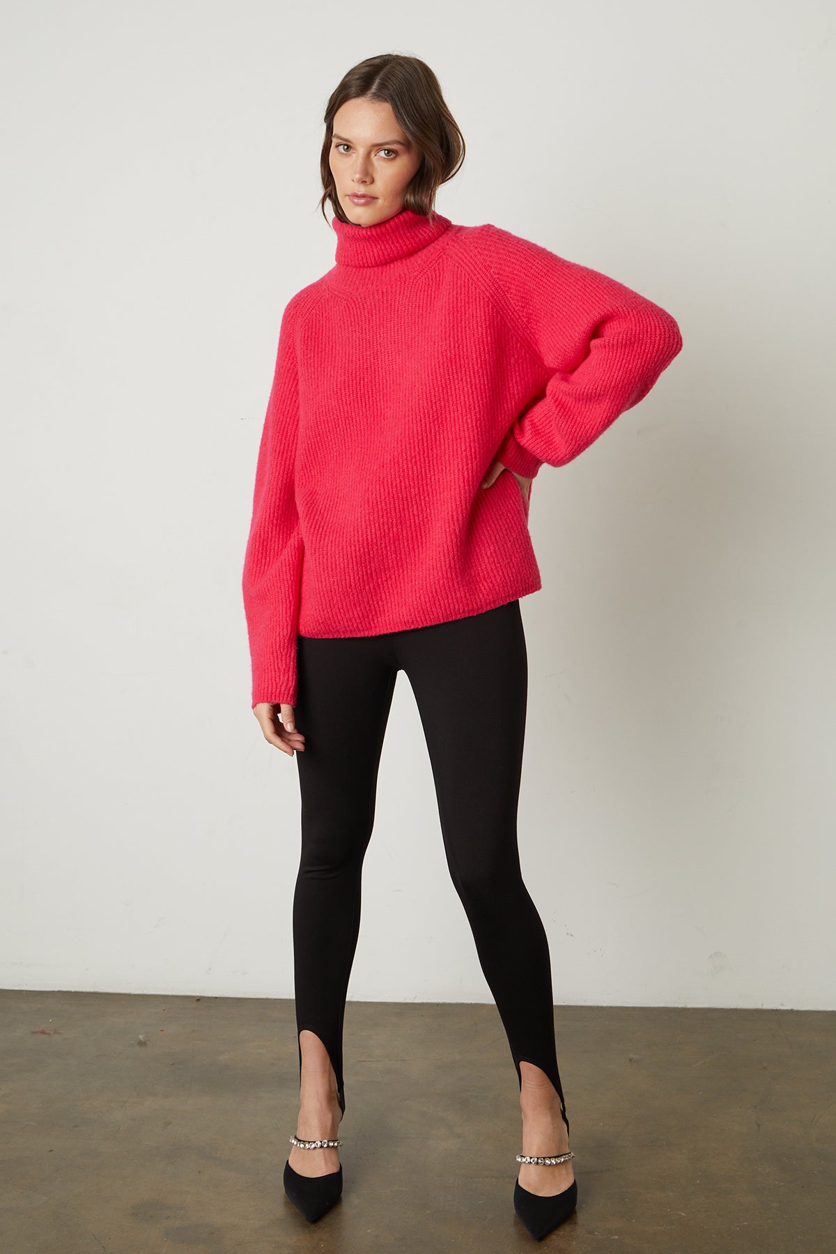   The model is wearing a Velvet by Graham & Spencer Judith turtleneck sweater and black leggings. 