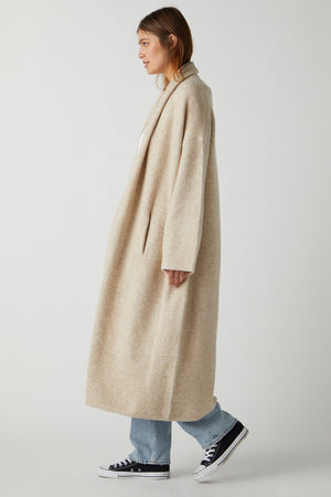 A woman wearing a Velvet by Jenny Graham CARMEL COAT in beige.
