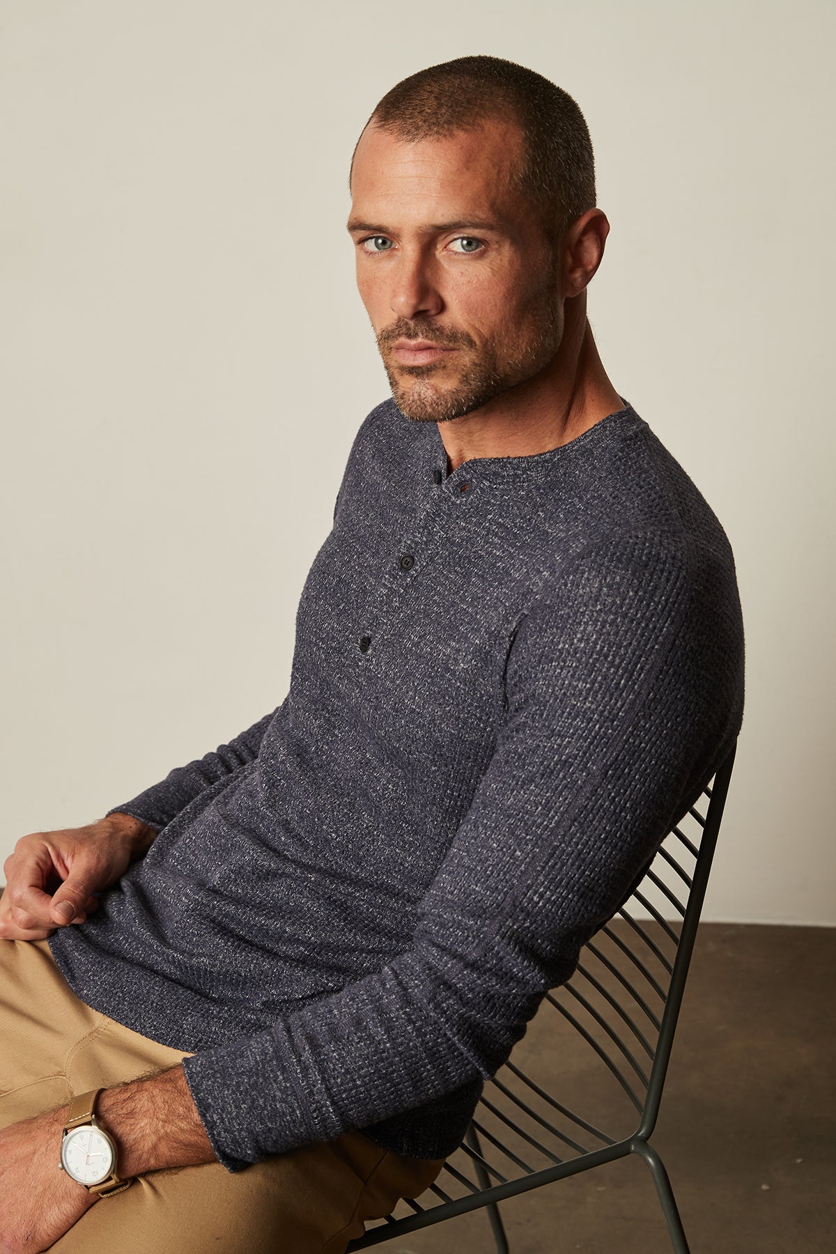   Model sitting in chair wearing Anthony Thermal Henley navy blue with Aiden pant in khaki 