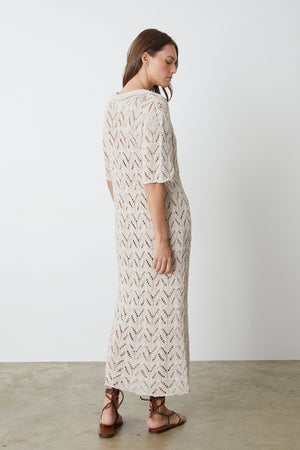 Jacqueline Crochet Stitch Maxi Dress in putty with brown sandals full length back, woman standing with head over shoulder