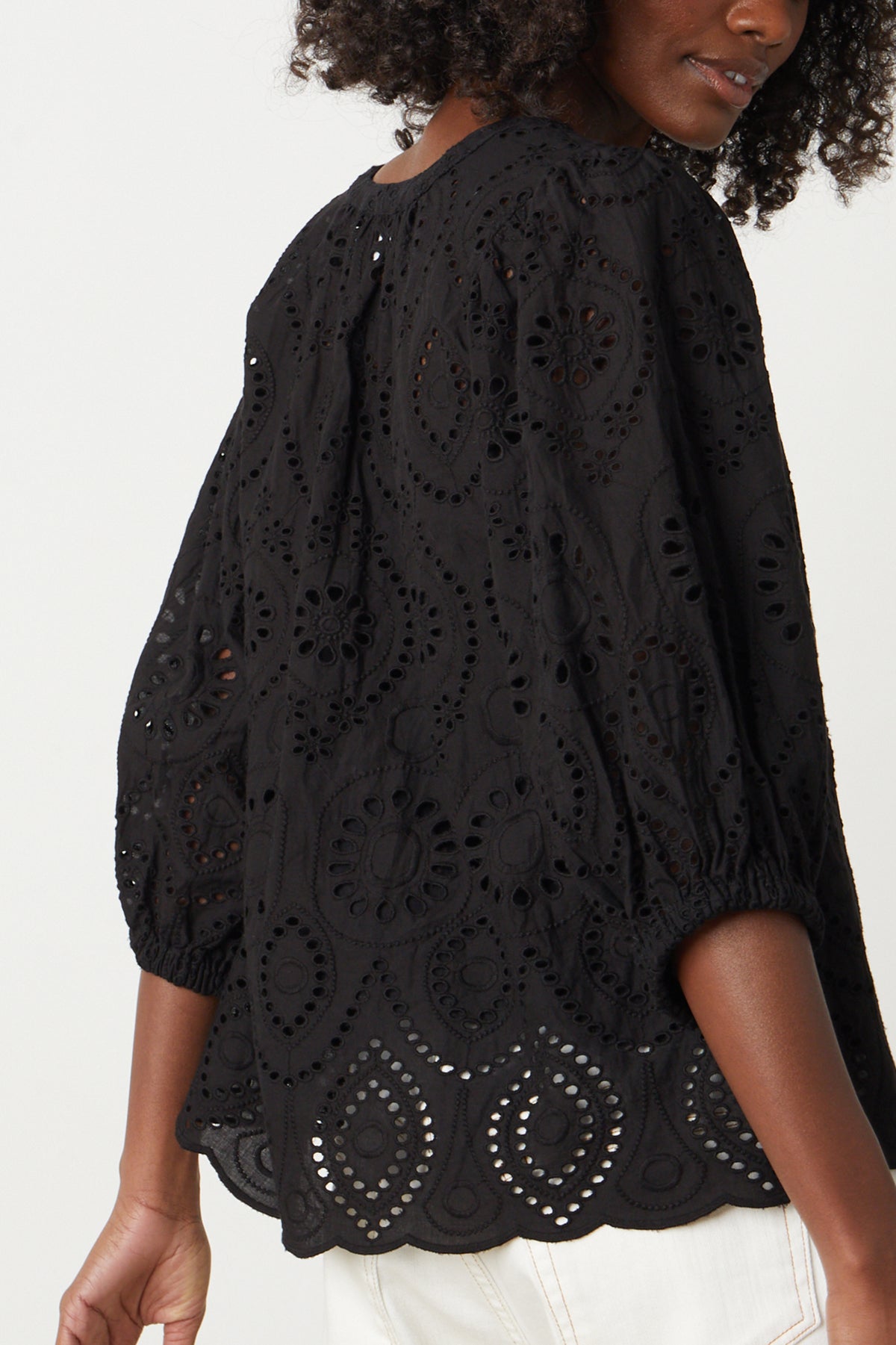   the back view of a woman wearing a Velvet by Graham & Spencer QUINN EYELET V-NECK TOP blouse. 