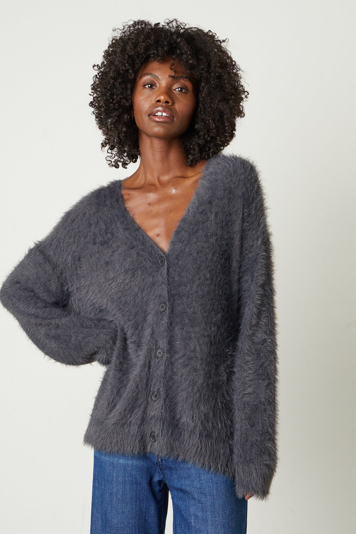 Model standing with hand on hip wearing Barb Feather Yarn Button Front Cardigan in charcoal grey front-25548655067329
