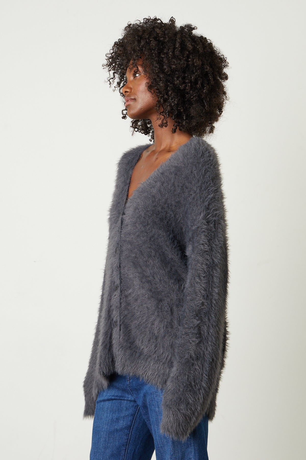   The model is wearing a Velvet by Graham & Spencer BARB FEATHER YARN BUTTON FRONT CARDIGAN. 