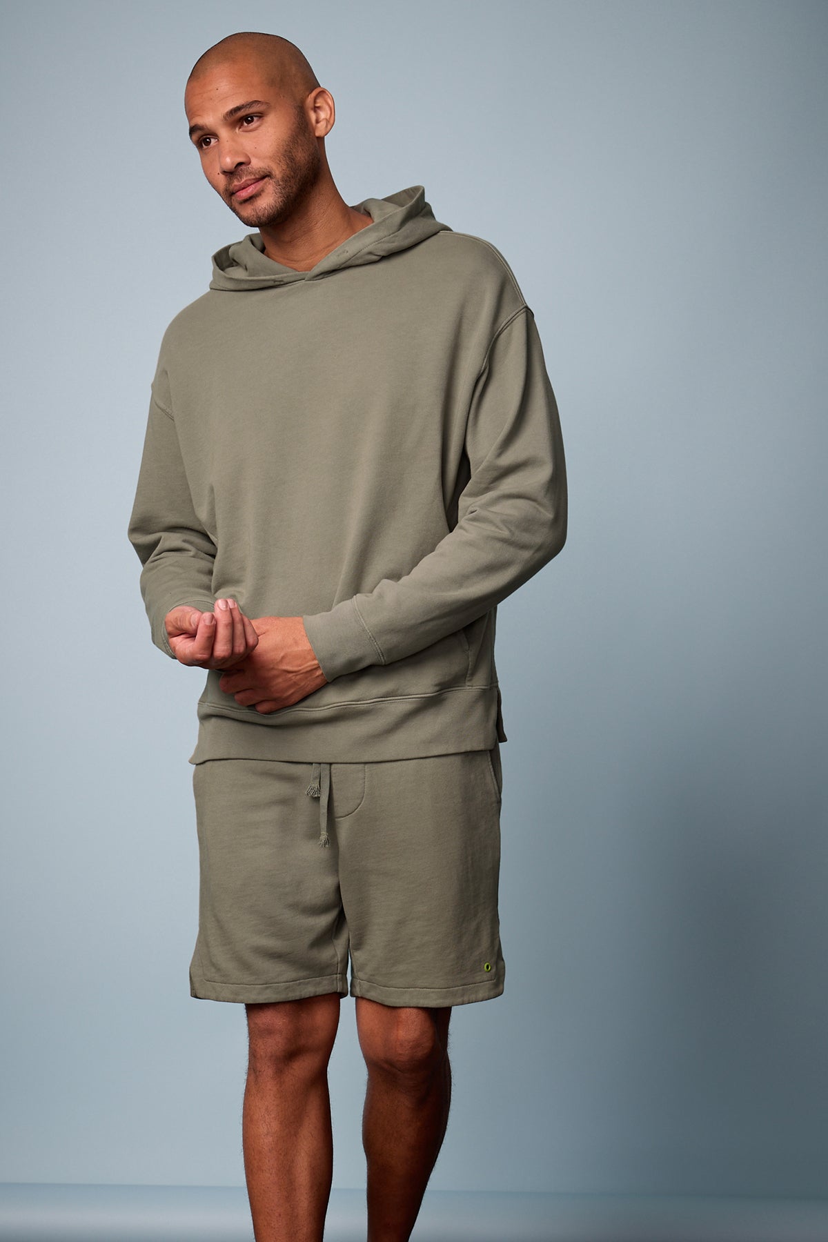 Lookbook image of Kane short in camp muted green french terry with Dan Hoodie, blue background, front-26249387049153