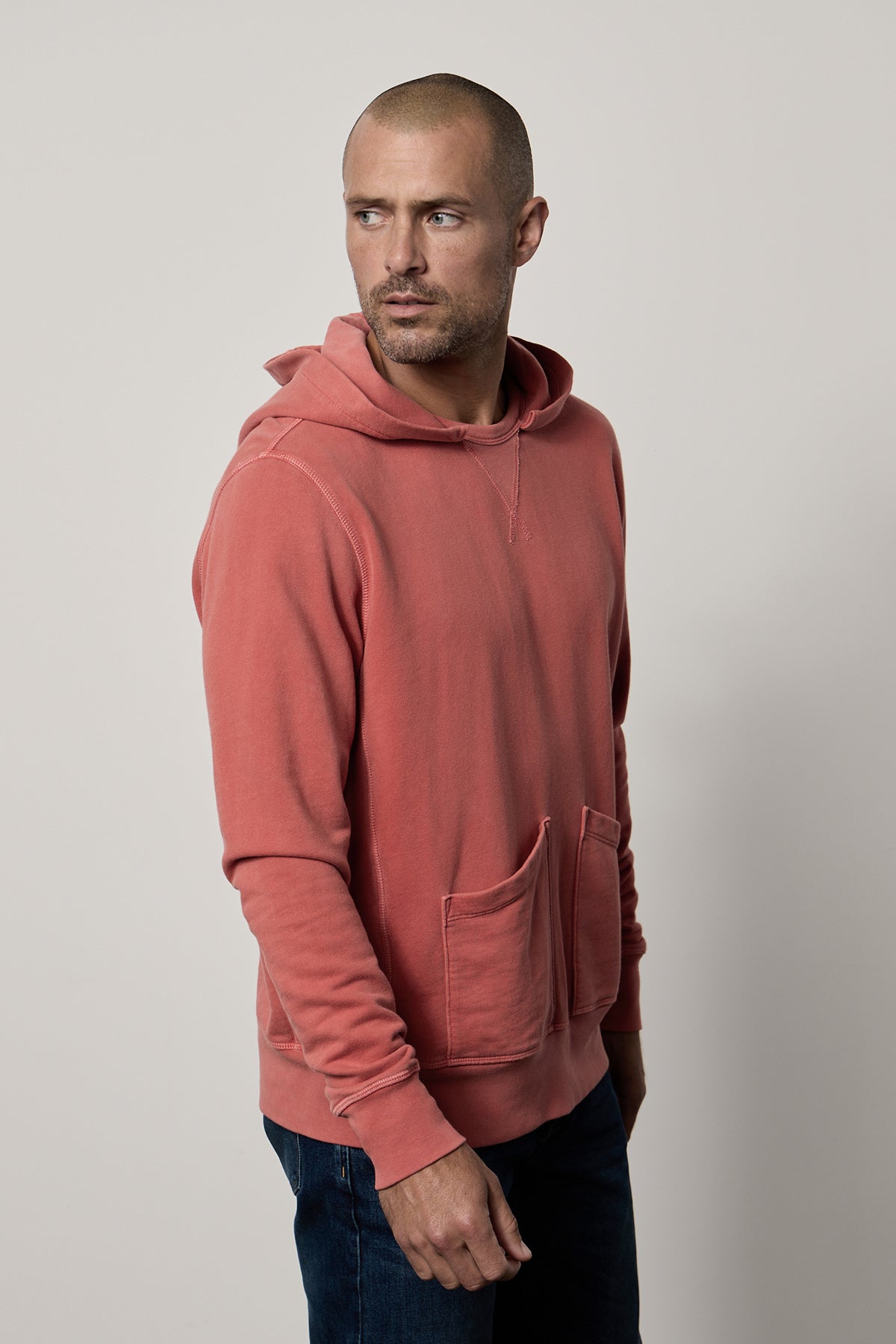   A man wearing a GRANT FRENCH TERRY HOODIE, a comfortable Velvet by Graham & Spencer garment dye with pockets. 