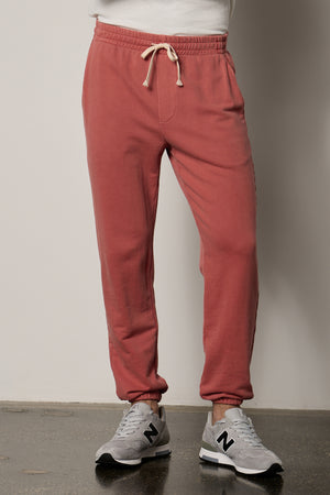 a man wearing Velvet by Graham & Spencer NELSON FRENCH TERRY JOGGER sweatpants and white sneakers.