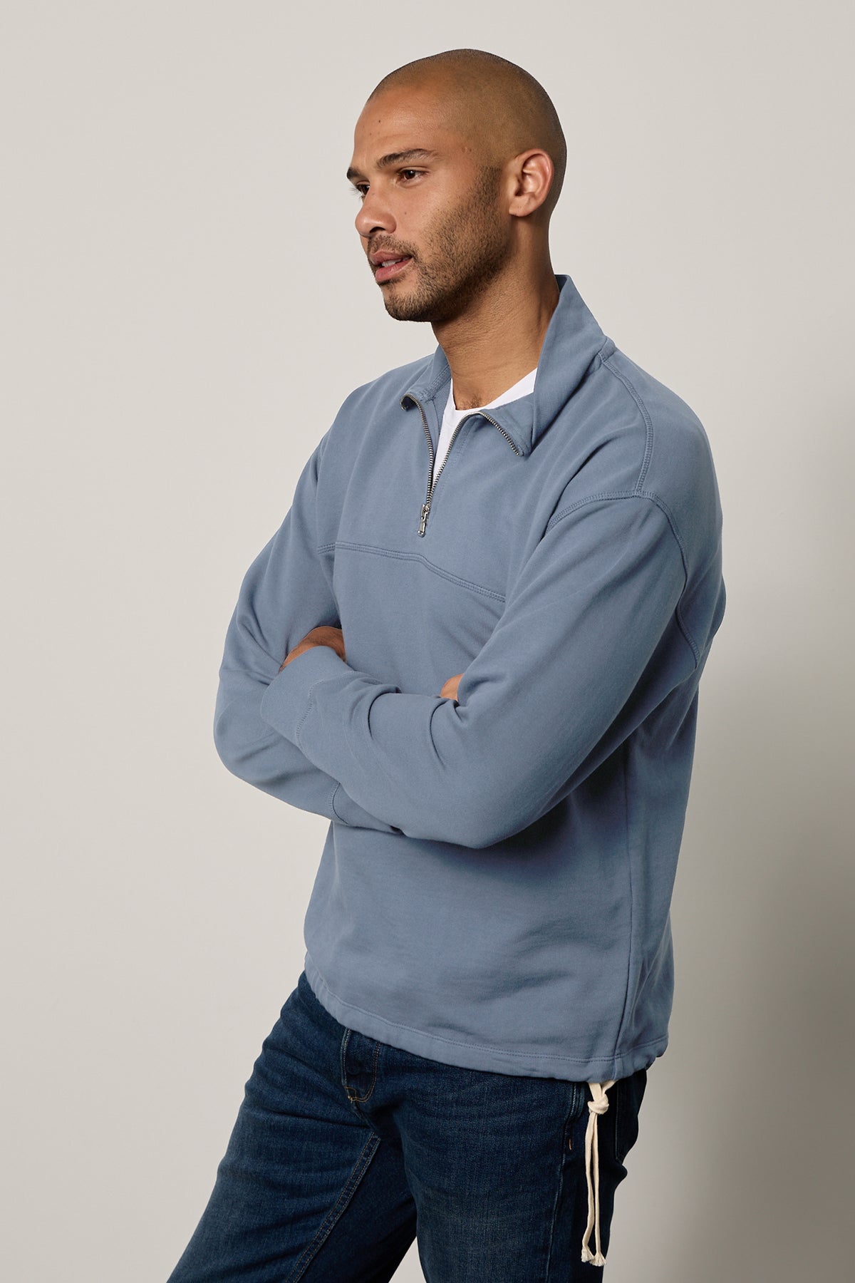 A man in jeans and a medium-weight knit Velvet by Graham & Spencer Patrick quarter-zip sweatshirt.-26215485866177
