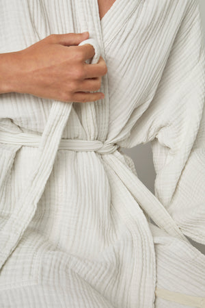 a woman wearing a Jenny Graham Home COTTON GAUZE ROBE with a belt.