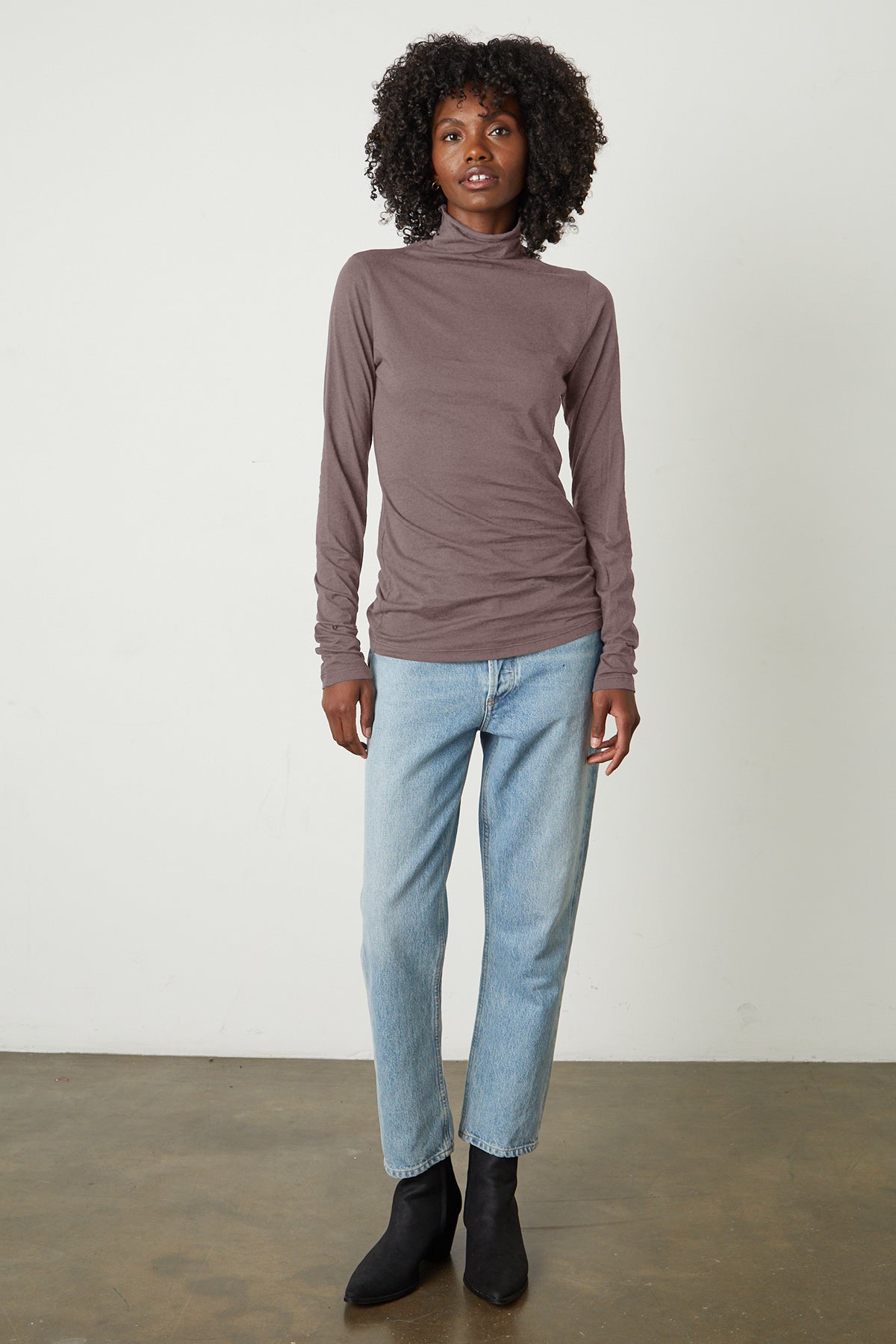Talisia Gauzy Whisper Fitted Mock Neck Tee in Fawn with light blue denim and black boots full length front-26011186168001