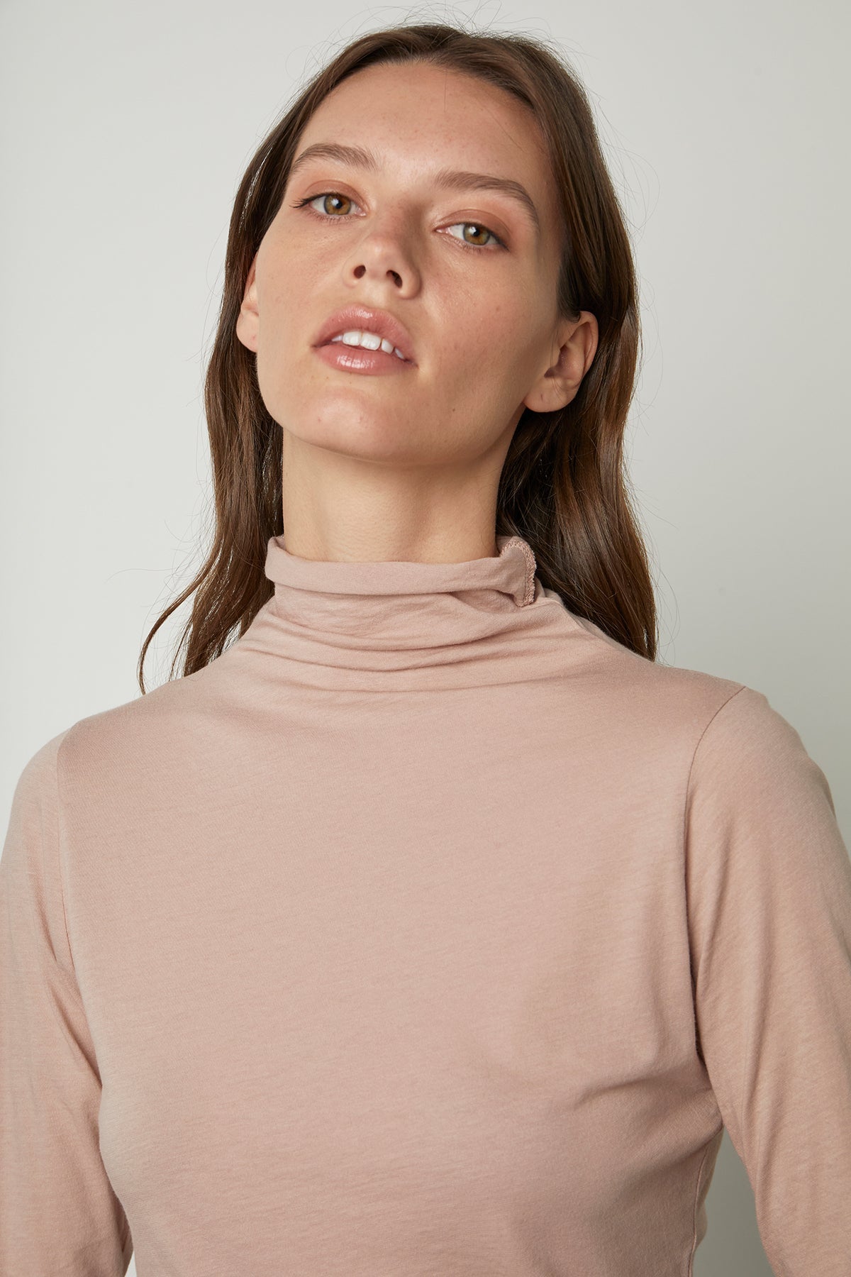 Model sitting in chair wearing Talisia Mock Neck Tee in rosegold front  detail-26011186036929