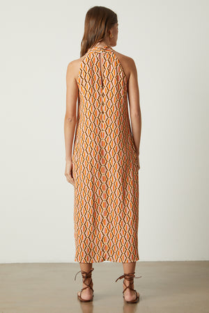 Caterina dress in orange geometric pattern gold earrings and sandals back