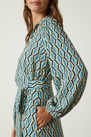 Gabriella wrap dress in blue geometric print crepe side close up detail with model's hand in pocket