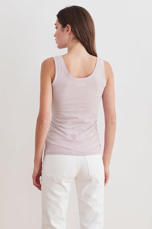 The back view of a woman wearing a Velvet by Graham & Spencer MOSSY GAUZY WHISPER FITTED TANK and white jeans.