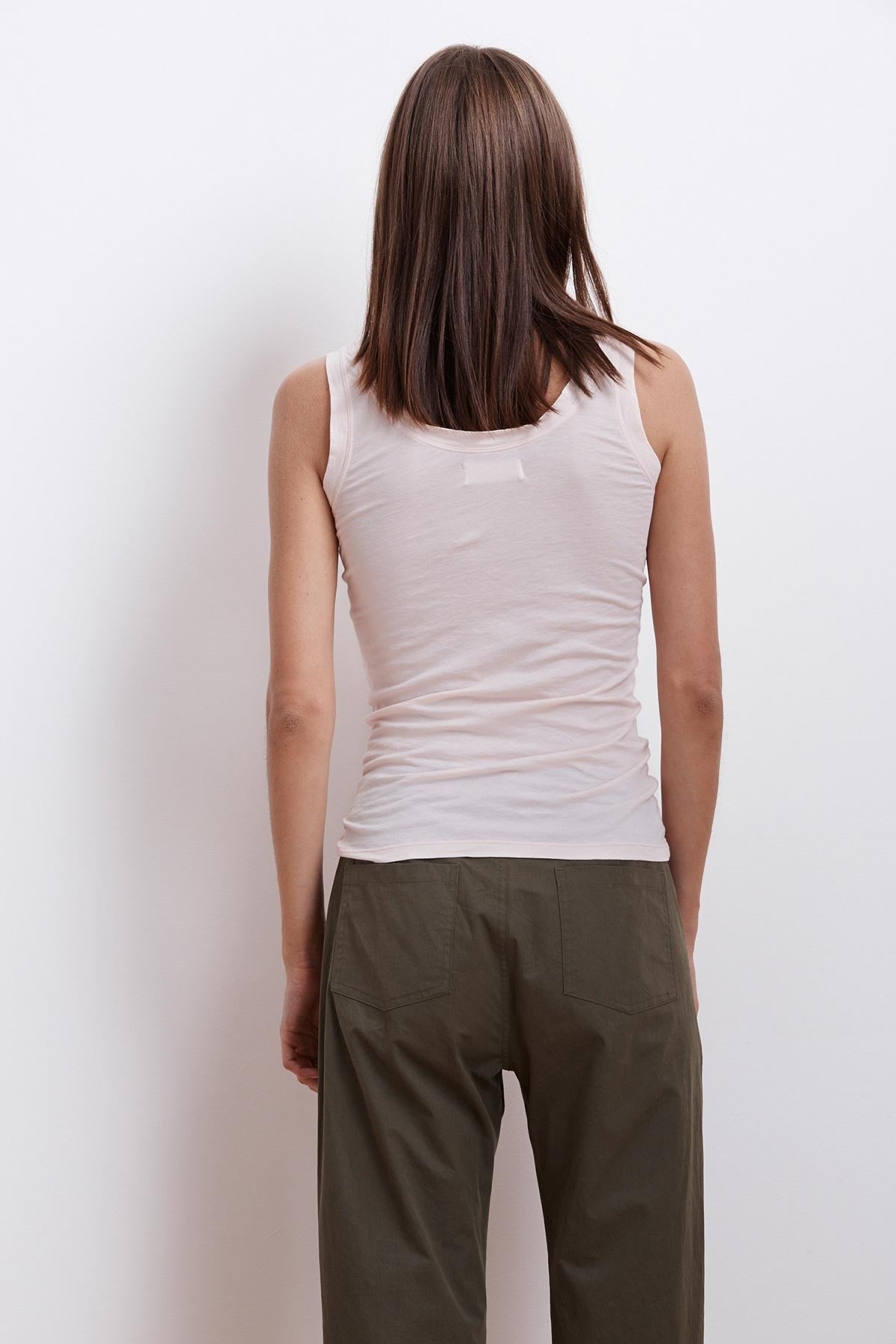 The back of a woman wearing khaki pants and a MOSSY GAUZY WHISPER FITTED TANK by Velvet by Graham & Spencer.-23854475411649