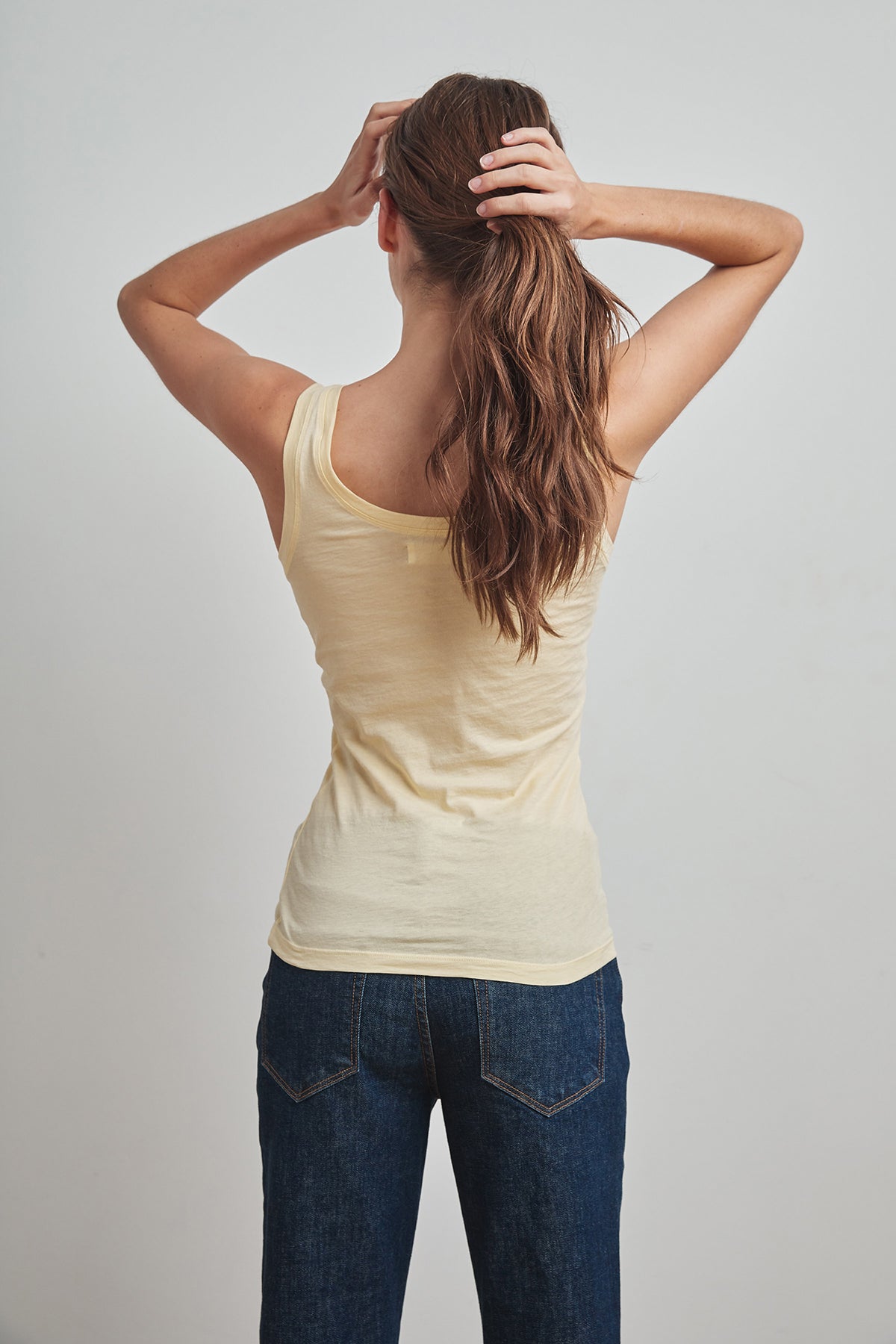   The back view of a woman wearing MOSSY GAUZY WHISPER FITTED TANK by Velvet by Graham & Spencer, perfect for warmer days. 
