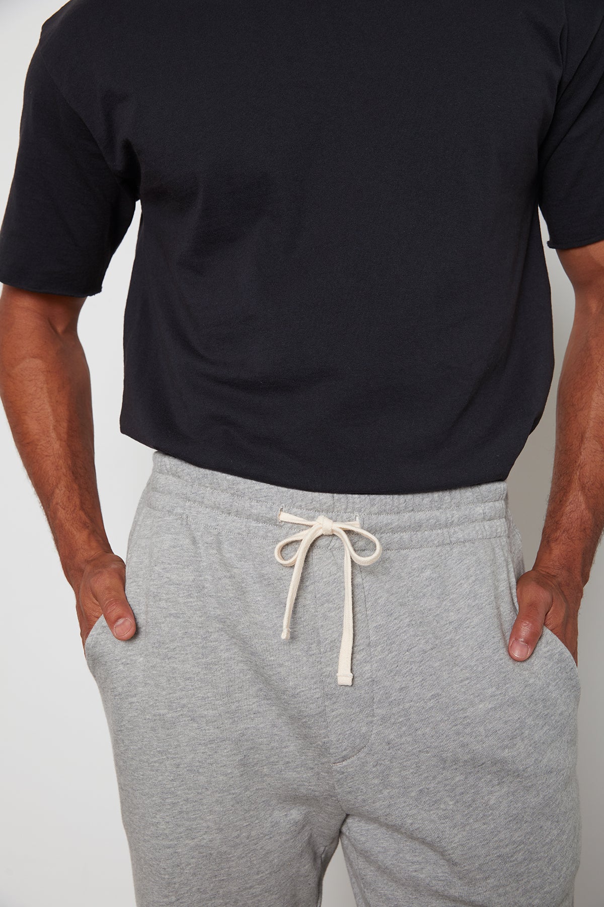 A man wearing a Velvet by Graham & Spencer JUDAS SWEATPANT with an elastic waist.-24522873897153