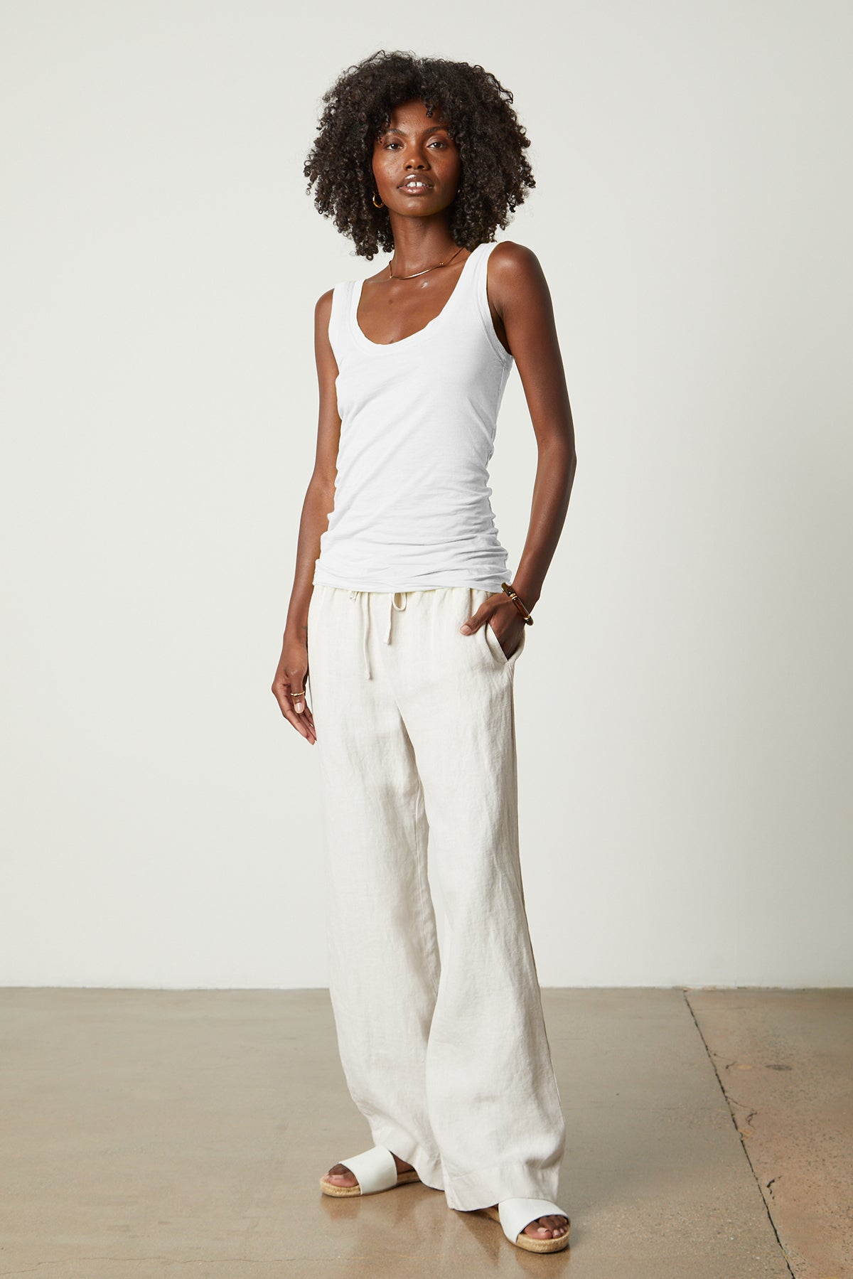 a woman wearing a Velvet by Graham & Spencer MOSSY GAUZY WHISPER FITTED TANK and wide leg pants.-26087958151361