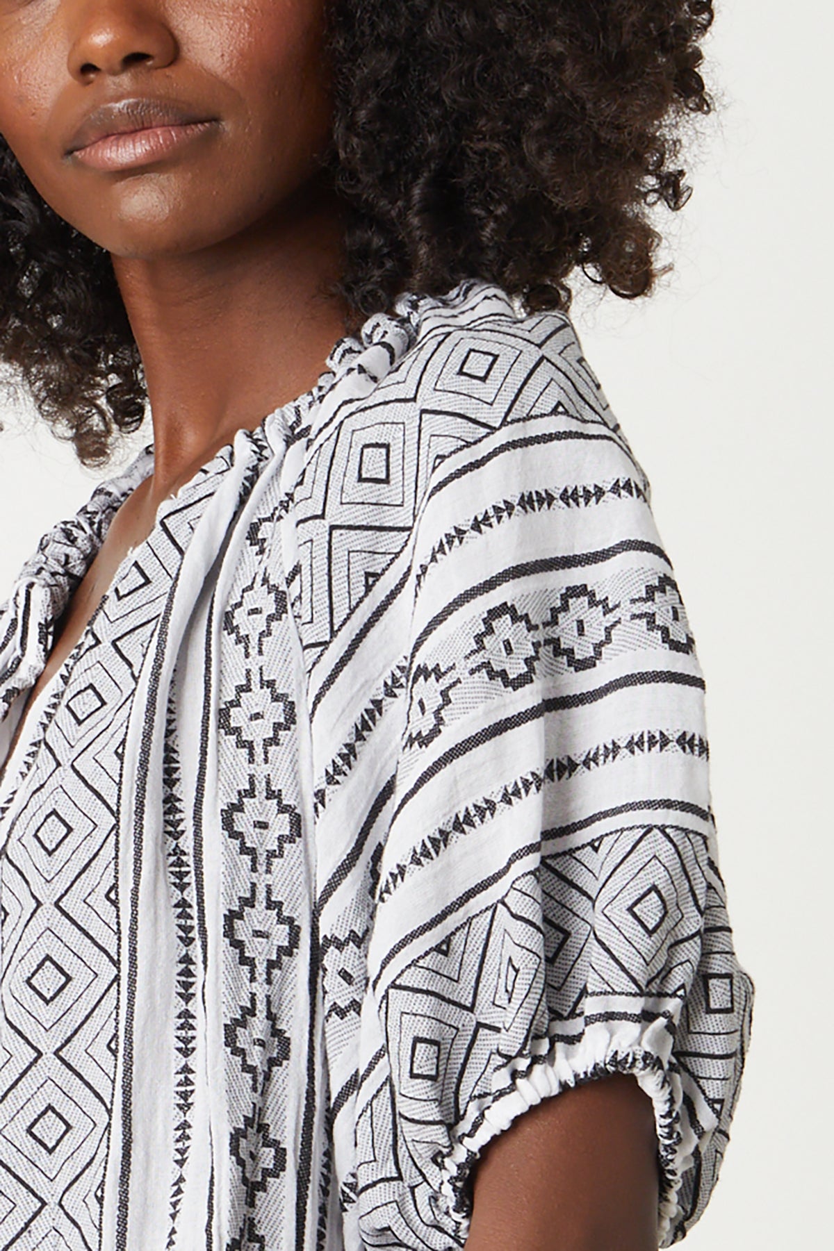A close up detail of a woman wearing a Velvet by Graham & Spencer KIMMY JACQUARD BOHO TOP.-26296063918273