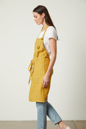 A woman wearing a durable Jenny Graham Home linen unisex apron and jeans.