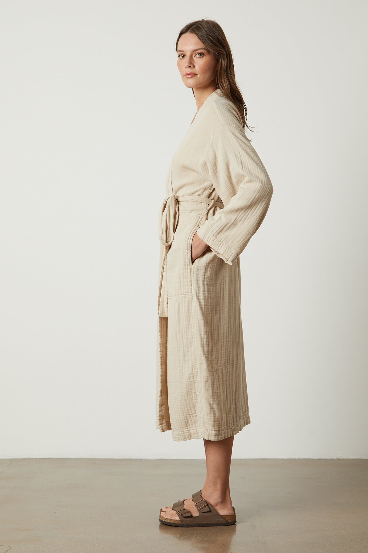   a model wearing a Jenny Graham Home COTTON GAUZE ROBE and sandals. 