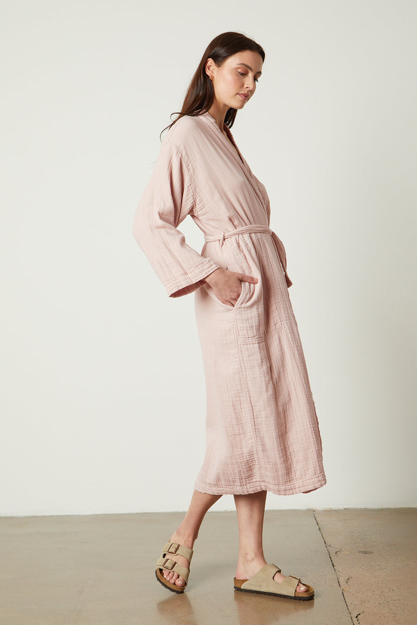 a model wearing a Jenny Graham Home pink linen robe and sandals.