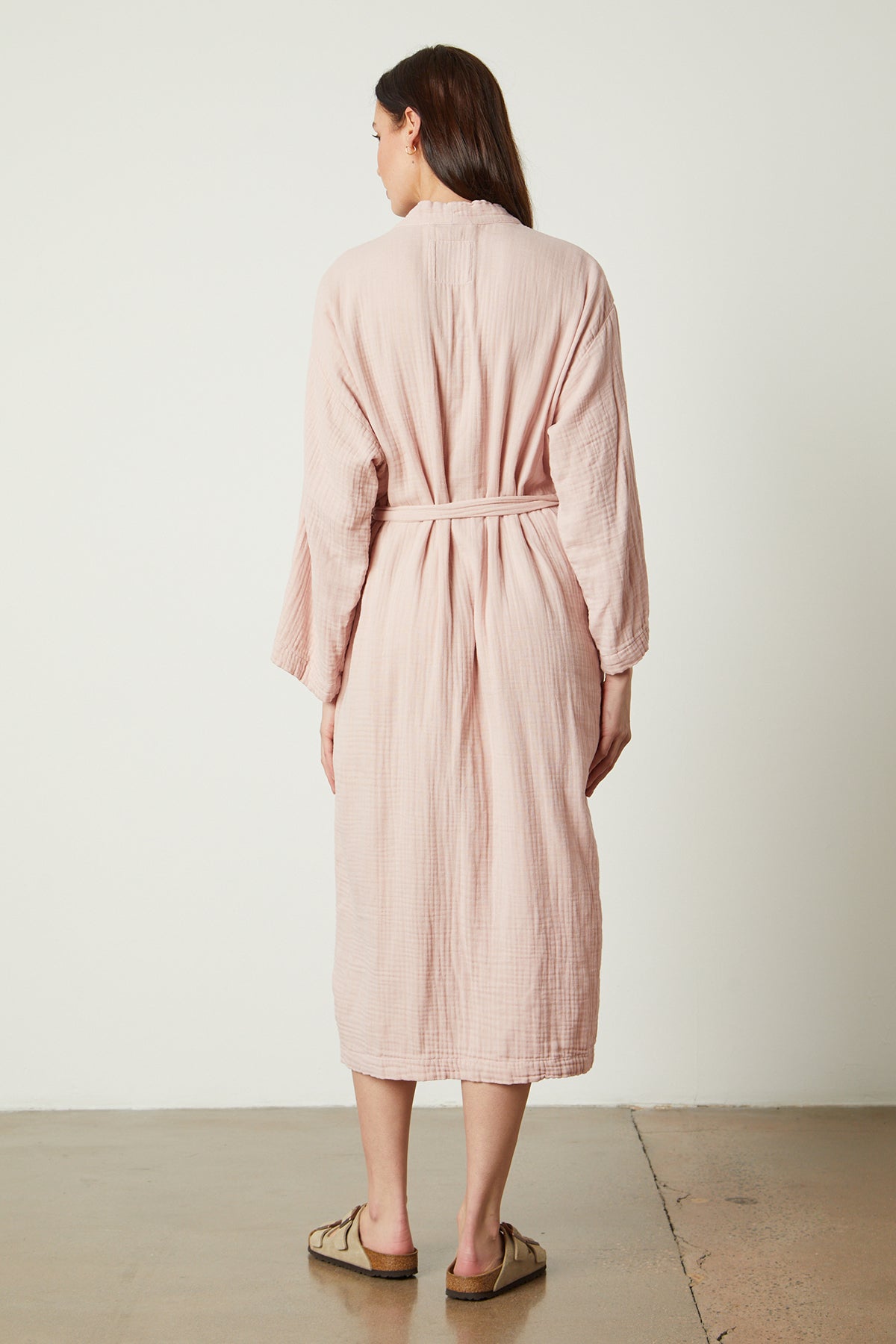 The back view of a woman wearing a Jenny Graham Home pink linen robe.-25519573598401