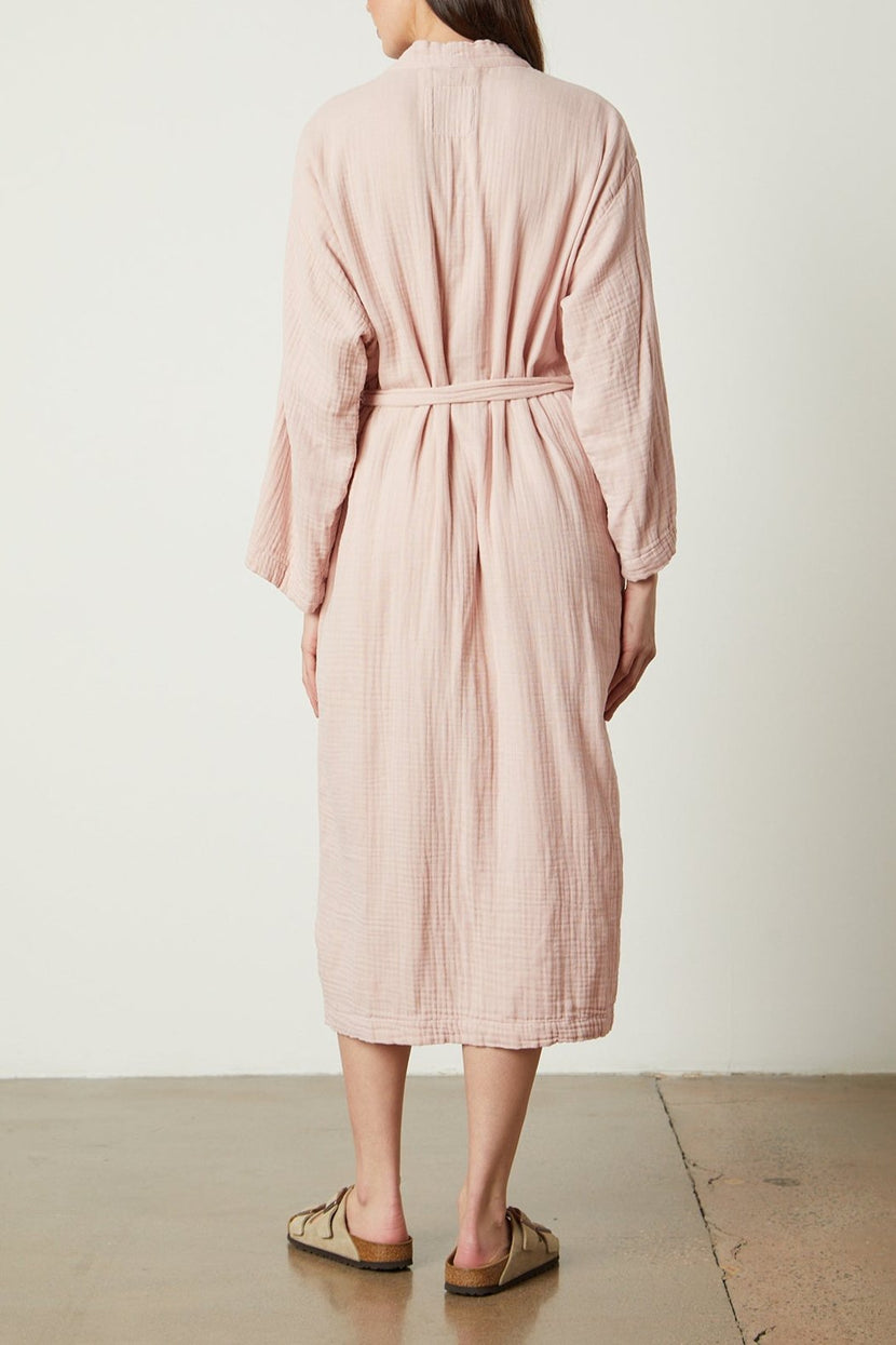 The back view of a woman wearing a Jenny Graham Home pink linen robe.