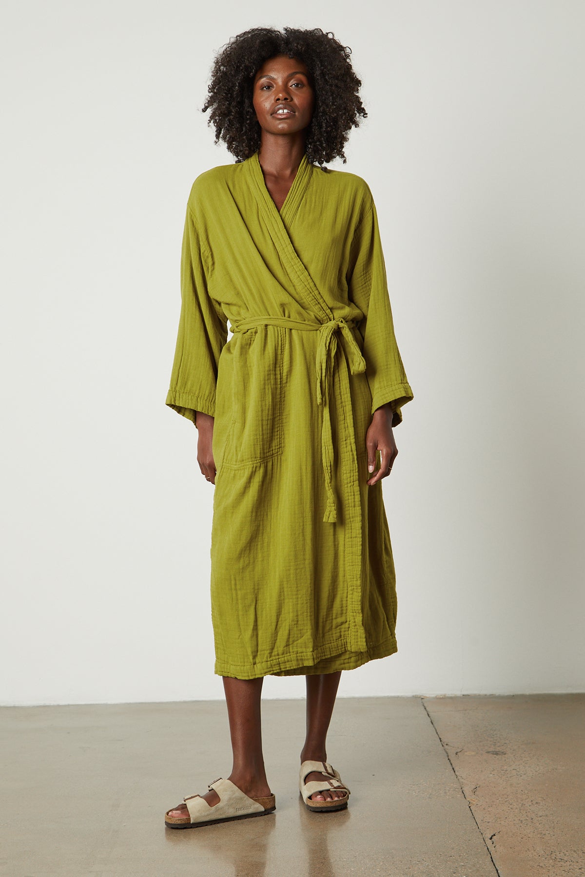   a woman wearing a green Cotton Gauze Robe from Jenny Graham Home and sandals. 
